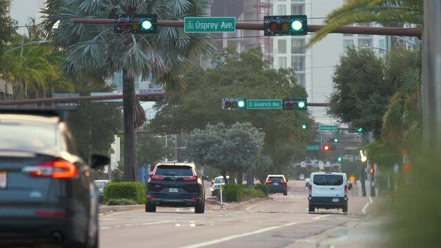 American street with driving cars at intersection with traffic lights in Tampa, Florida. USA transportation