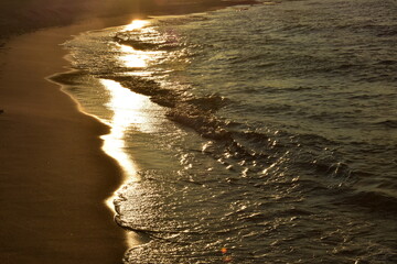 Fale na brzegu morza o zachodzie słońca - obrazy, fototapety, plakaty