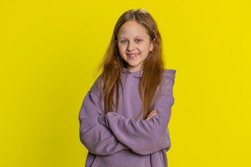 Fototapeta premium Portrait of happy young preteen child girl kid smiling friendly glad expression looking at camera dreaming resting relaxation feel satisfied good news. Teen cute children isolated on yellow background