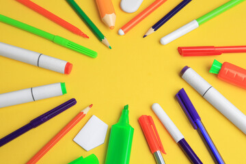 Frame of different school stationery on yellow background, flat lay with space for text. Back to school