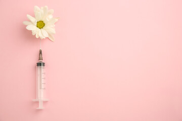 Medical syringe and beautiful chrysanthemum flower on pink background, top view. Space for text
