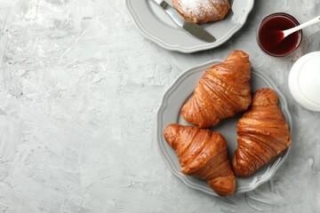 Flat lay composition with tasty croissants served on light grey textured table. Space for text