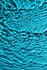 Rippled surface of clear water on light blue background, top view