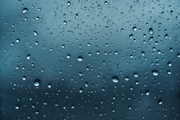 Melancholic Drizzle: Raindrops Clinging to a Moody Blue Window