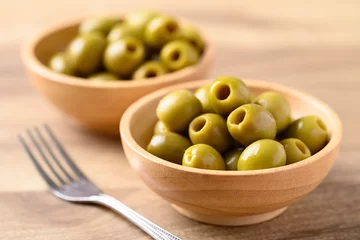 Keuken spatwand met foto Pickled olives, Pitted green olives in wooden bowl © nungning20