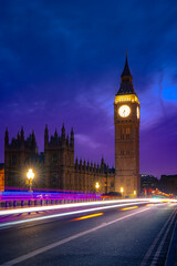 Exterior of historic buildings with glowing lights located against Big Ben tower at night in London...