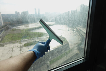Close up of man hand cleaning window glass 
