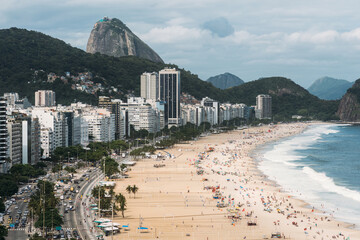 High perspective view of Copacabana Beach in Rio de Janeiro, Brazil with Sugarloaf mountain visible in the far background - obrazy, fototapety, plakaty