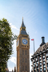 Low angle of aged building of famous Big Ben against clock tower located on street of London against blue sky background
