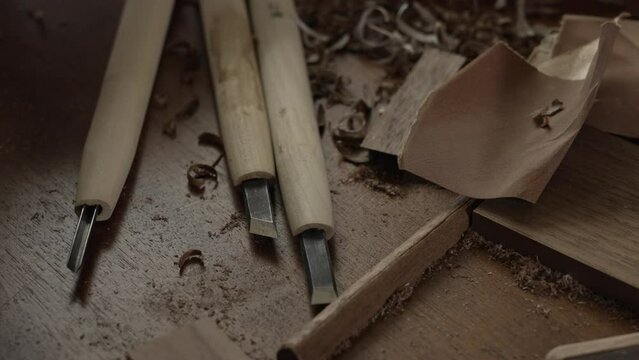 机に置かれた彫刻刀と作業をする職人の手元