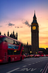 Fototapeta na wymiar Public transportation bus and cars on asphalt road near Big Ben or Clock Tower under picturesque sky in dusk in London city at night
