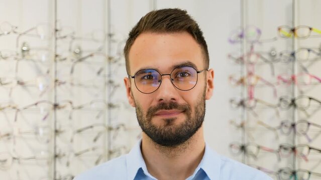 Portrait of handsome man picking new specs at optical shop