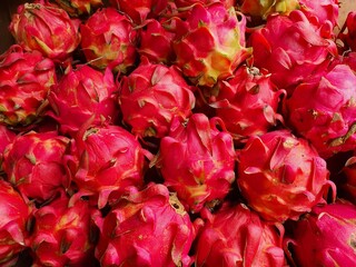 Close up pile of tasty fresh dragon fruits sold at the market as a background.