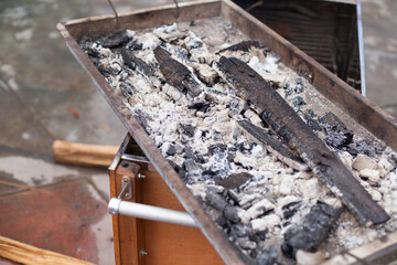 Photograph of charcoal in a source of a Chinese box type grill. Concept of ovens and grills.