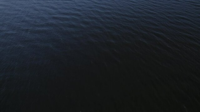 Aerial shot of calm waves creating textures in the vast ocean
