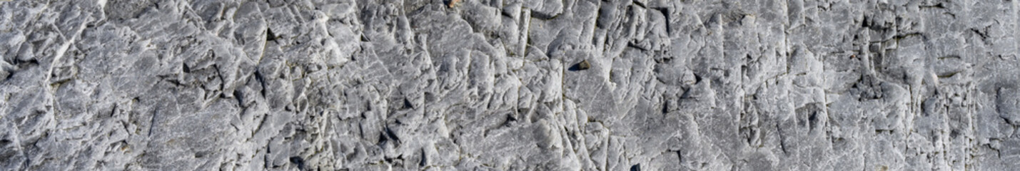 Roughly textured medium gray rock, as a nature background

