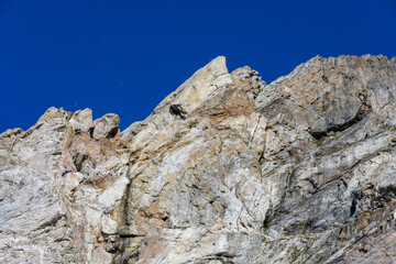 Graphic light colored rock formation against a rich blue sky, as a nature background
