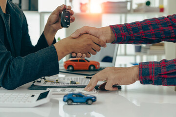 The dealer hands the car keys to the new owner. Sales, loan, finance, car rental, insurance,...