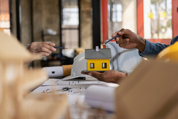 Group of engineers and working meeting and discussing construction planning with blueprints with architect equipment. Architects talking at table, teamwork and work flow construction concept.