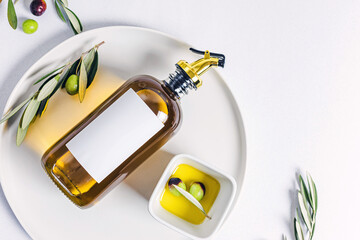 Bottle of olive oil and leaves on the plate, still life composition,