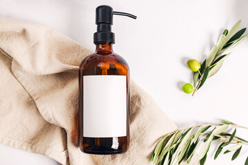 Soap or shampoo dispenser bottle and olive leaves, product mock-up - obrazy, fototapety, plakaty