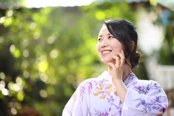 Japanese woman in yukata in green park