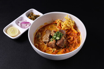 Khao Soi Thai Curry soup isolated in black background