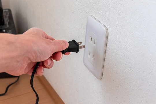 壁のコンセントに機器の電源プラグを差し込む
