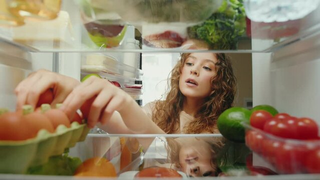 Young Woman Opening Fridge Door with Healthy Food and Taking Products. Hungry Person Cooking Meal and Choosing Ingredients of Refrigerator. Life of Attractive Lady Selecting Storing Groceries to Eat
