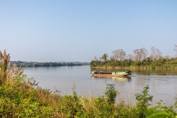 Fototapeta premium Wooden boat on its way upstream on the Mekhong River, Ban Saeo, Thailand