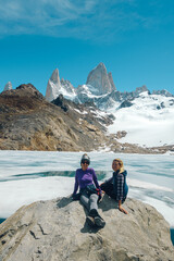two friends have fun posing for a photo with Fitzroy Mountain in the background