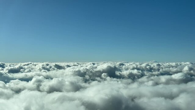 Clouds scene, unique pilot&rsquo;s view shot from an airplane cabin while flying over the clouds in a bright and sunny winter day. 1000m high.