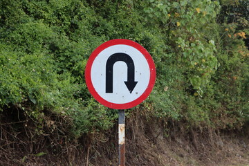 A u turn sign on the rural mountain road