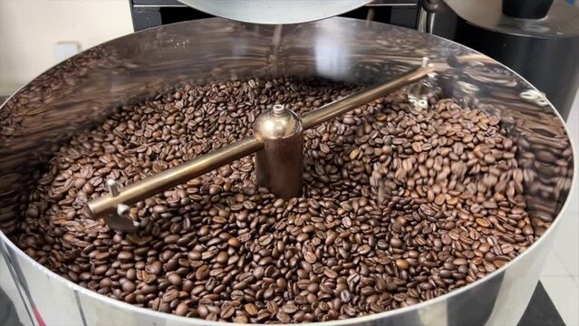 Freshly roasted coffee beans in the state-of-the-art roasting machine at our premium roastery facility, ensuring unparalleled quality and aroma for your perfect cup of coffee. Immerse yourself in the.