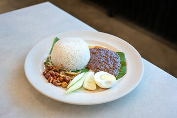 Nasi Lemak, a malay style meal of fragrant rice cooked in coconut milk and eaten together with chilli paste, egg, anchovies, fried peanuts and cucumber.