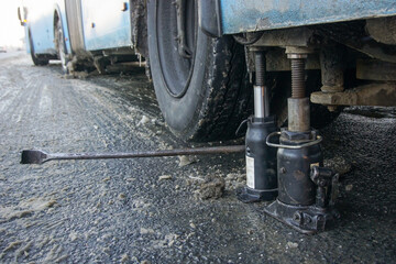 A city bus wheel is hung on jacks for repair or replacement.