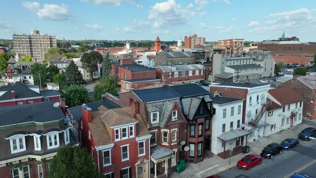 Victorian-style row houses on a city street. Aerial establishing shot of small American city.