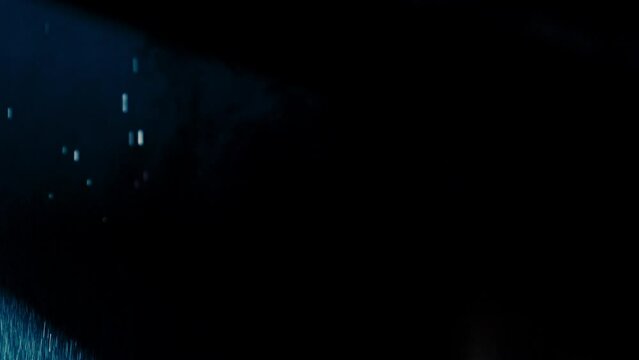 Abstract dark background with blue cold flashing light beam spot and laser illuminate falling rain and smoke. Wide beams in the foreground and glashing narrow beams in background.