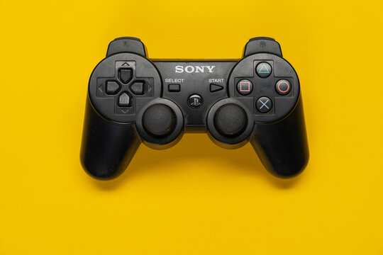 Controller der PS3 Playstation Spielekonsole von Sony vor einfarbig gelben Hintergrund, top view