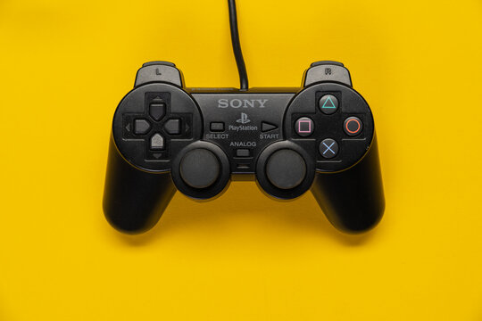 Controller der PS2 Playstation Spielekonsole von Sony vor einfarbig gelben Hintergrund, top view