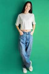 Full length portrait of a young girl in a white T-shirt and jeans.