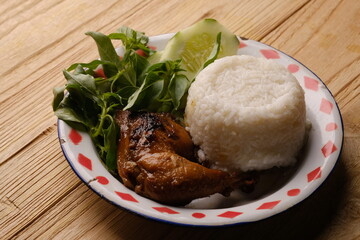 Ayam Panggang. ayam bakar. roasted chicken with soy sauce and spices. on vintage plate with rice.. Indonesian food. grilled chicken.