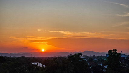 Beautiful sunset in the mountains. Sunset with beautiful orange evening sky and silhouette of trees. Dramatic sunrise