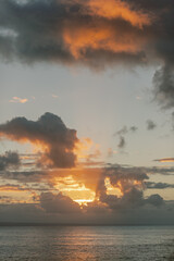 Fototapeta na wymiar Sunset over Dominican ocean: vibrant orange clouds, tranquil waters.