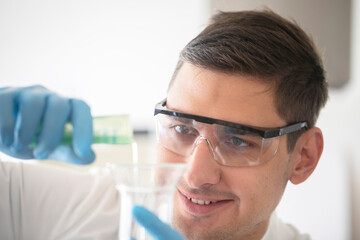 scientist male with lab glasses and gloves working - obrazy, fototapety, plakaty