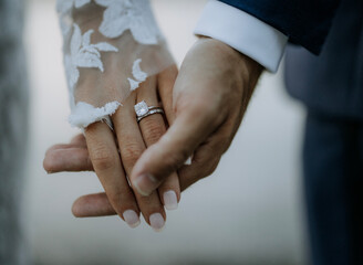Man and woman just married with diamond ring and lace holding hands