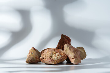 Piece of granite stone on white background with shadows