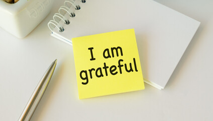 Note paper on white background with handwritten text I AM GRATEFUL - concept of gratitude , means...