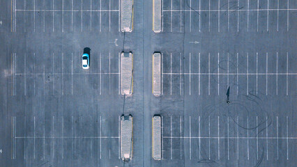 Large parking lot with one car and one person