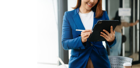 Confident business expert attractive smiling young woman holding digital tablet  on desk in creative office...